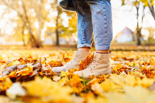 Frau in braunen Lederschuhen im herbstlichen Laub – Symbolbild für den richtigen Herbstschuh